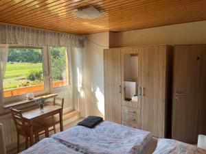 a bedroom with a bed and a desk and a window at Chalupa pod Pustevnami in Trojanovice