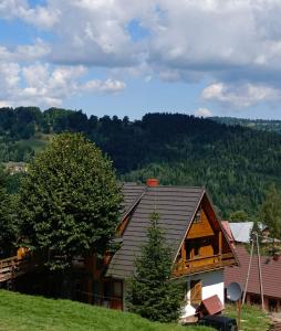 una casa in cima a una collina con un albero di 650m n.p.m. a Zawoja