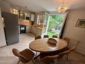 a kitchen and dining room with a table and chairs at Appartement RDC avec jardin au cœur de Barbizon 2 a 8 personnes in Barbizon