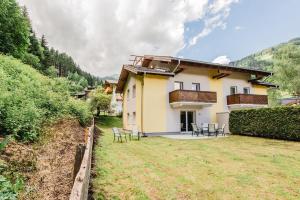 a house with chairs and a yard in front of it at Chalet Vergissmeinnicht in Zell am See