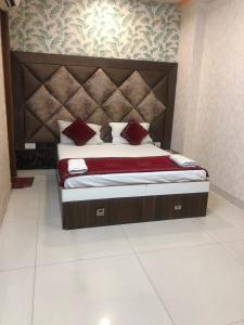 a bedroom with a large bed with red pillows at Hotel Robin Inn in Amritsar