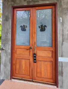 une porte en bois avec deux chats sur les fenêtres dans l'établissement Rimtharnn Homestay Maewin, à Mae Wang