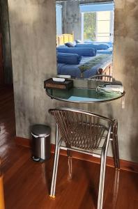 une table en verre avec une chaise et un miroir dans l'établissement Rimtharnn Homestay Maewin, à Mae Wang