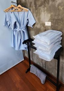 une pile de chemises sur une étagère dans une chambre dans l'établissement Rimtharnn Homestay Maewin, à Mae Wang