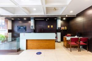 a lobby with a counter and chairs in a building at Hotel Kalinga in Indore