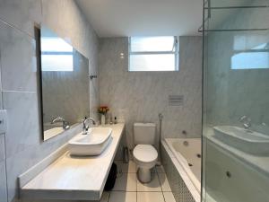a bathroom with a sink and a toilet and a shower at Apartamento em Belo Horizonte in Belo Horizonte
