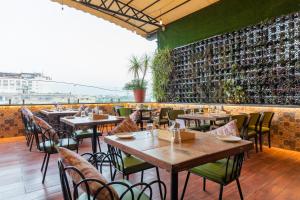 un restaurante con mesas y sillas y una pared de botellas de vino en Hotel Kalinga, en Indore