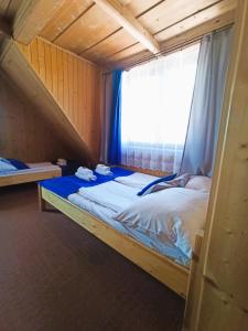 Ce lit se trouve dans un dortoir doté d'une fenêtre. dans l'établissement Dom Wczasowy Krystyna, à Bukowina Tatrzańska