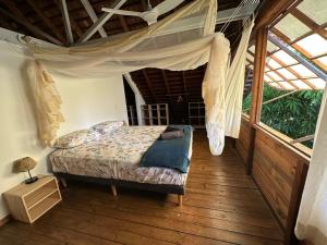 a bedroom with a bed with a mosquito net at Moorea Pool & Lagoon House in Moorea