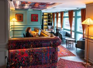 GINGER Hotel في تبليسي: امرأة تجلس في مكتب في غرفة الفندق