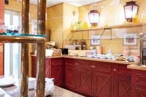 a kitchen with red cabinets and a pig on the floor at Strandhotel Sylt Westerland in Westerland