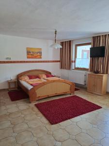 Un dormitorio con una cama grande y una alfombra roja en Ferienhaus Fabio, en Thürnthal