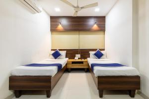 2 camas en una habitación con espejo en Hotel Kalinga, en Indore