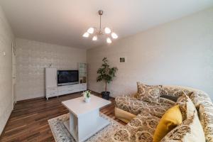 a living room with a couch and a tv at A.P. Apartment in Šiauliai