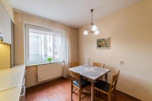 a dining room with a table and a window at A.P. Apartment in Šiauliai