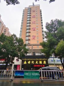 a tall building with a sign in front of it at Century Hotel Tongren in Tongren