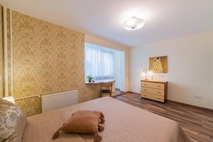 a bedroom with a large bed and a window at A.P. Apartment in Šiauliai