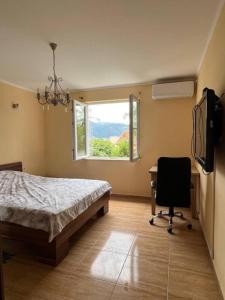 um quarto com uma cama, uma secretária e uma janela em Serena em Bijela