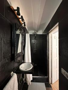 a black bathroom with a sink and a mirror at Loft en Mojácar in Mojácar