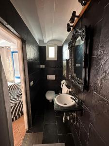 a black bathroom with a sink and a mirror at Loft en Mojácar in Mojácar