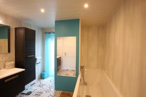 y baño con bañera y lavamanos. en Le cosy 40 - maison typique au centre de Malmedy en Malmedy