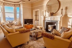a living room with two chairs and a fireplace at Villa by the Sea in Broughty Ferry