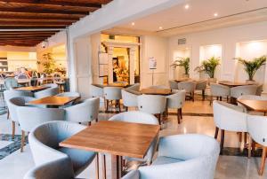 Real Bellavista Hotel & Spa في ألبوفيرا: مطعم فيه طاولات وكراسي في الغرفة