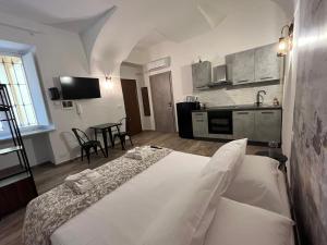 a bedroom with a white bed and a kitchen at Chagall Charme in Asti