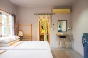 Postel nebo postele na pokoji v ubytování Baansuansabai Phloenpanmai Resort บ้านสวยสบาย เพลินพรรณไม้ รีสอร์ท อัมพวา