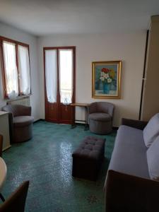 ein Wohnzimmer mit Sofa, Stühlen und einem Tisch in der Unterkunft Venice lagoon suite in Chioggia