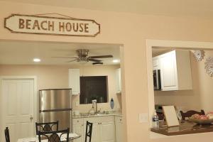 a kitchen with a beach house sign on the wall at Cozy By The Sea - Hutchinson Island - A in Fort Pierce
