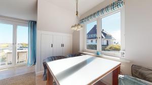 a kitchen with a table and two windows at Beachhouse Beachhouse 5 in Hörnum