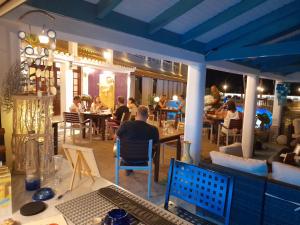 un grupo de personas sentadas en mesas en un restaurante en Sunsea Wellness Resort, en Agios Stefanos