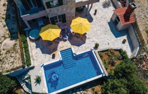 Villa Petmat - with private pool and 6 bedrooms في دوبروفنيك: اطلالة جوية على مسبح مع مظلات