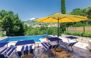 a pool with tables and a yellow umbrella at Villa Petmat - with private pool and 6 bedrooms in Dubrovnik