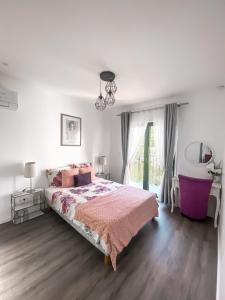 a white bedroom with a large bed and a window at Paris Dream Villa in Villejuif
