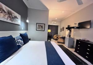 ein Schlafzimmer mit einem großen Bett und ein Wohnzimmer in der Unterkunft Turaco Lodge - No Loadshedding in Marloth Park