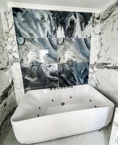 a white bath tub in a bathroom with marble walls at Paris Dream Villa in Villejuif