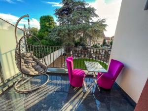 a balcony with pink chairs and a table and a fence at Paris Dream Villa in Villejuif