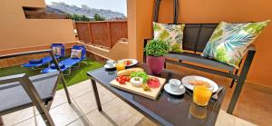 - une table avec un plateau de nourriture sur le balcon dans l'établissement Ferienhaus SUN & OCEAN in Gran Tarajal, à Gran Tarajal