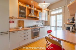 a kitchen with white cabinets and a table with chairs at Appartamento Via Madonnetta by PortofinoVip in Santa Margherita Ligure