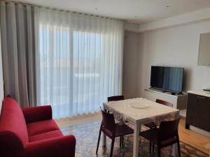 a living room with a table and chairs and a television at Carboni Paradise Apartment in Cupra Marittima