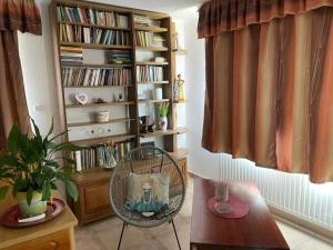 a living room with a chair and a book shelf at Guesthouse Kohári in Egerszalók