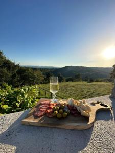 a wooden cutting board with food and a glass of wine at Zerko Holiday Home - Vineyard Chalet With Sauna and Jacuzzi FREE in Mirna