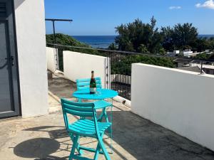 un tavolo con due sedie e una bottiglia di vino di Seaview Terrace Appartement a Flic-en-Flac