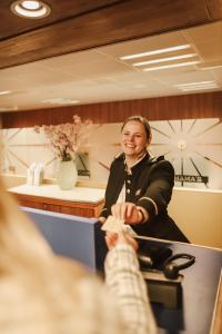 Una donna in piedi davanti a uno specchio di ss Rotterdam by WestCord a Rotterdam