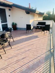 a deck with chairs and a table and a piano at Casa vacanze al mare in Pietrasanta