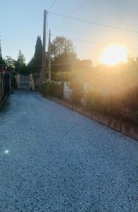 a gravel driveway with the sun setting in the background at Casa vacanze al mare in Pietrasanta
