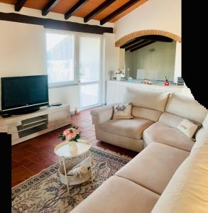 a living room with a couch and a tv at Casa vacanze al mare in Pietrasanta