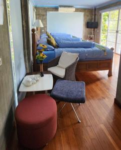 - une chambre avec un lit, une table et un tabouret dans l'établissement Rimtharnn Homestay Maewin, à Mae Wang